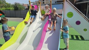 Des enfants descendent le toboggan à 3 glissières